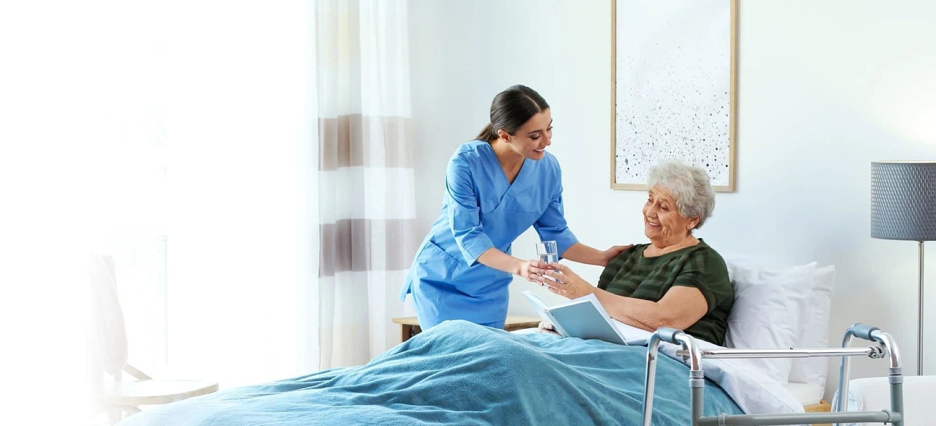 A nurse is helping an elderly patient in bed.