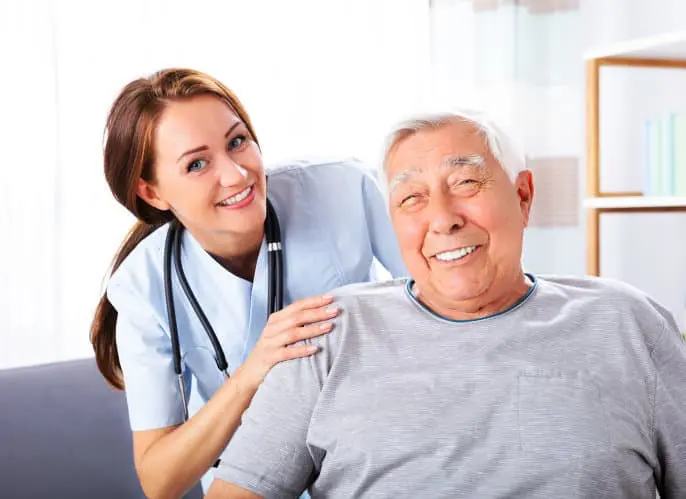 A nurse is standing next to an older man.